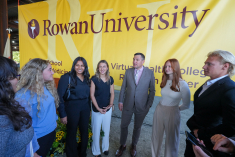 Matthew Edson and students in front of a Rowan University banner.